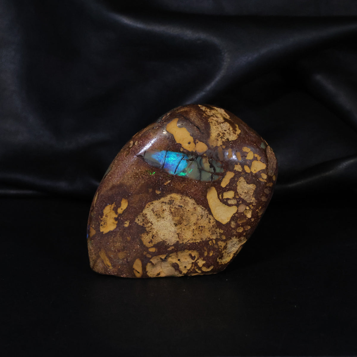 Opal specimen sparks of color in sandy iron stone