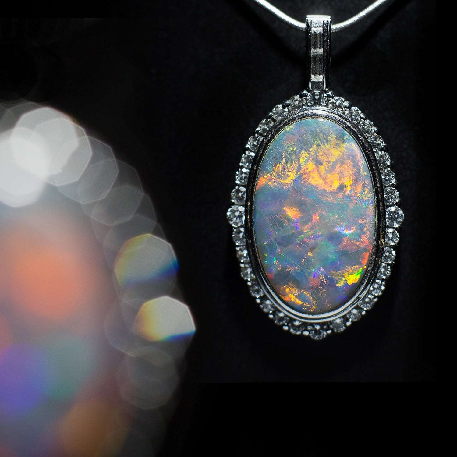 Australian black opal pendant in platinum with red fire and diamond halo — Lightning Ridge