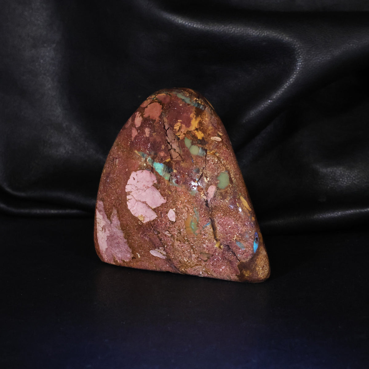 Opal specimen sparks of color in sandy iron stone