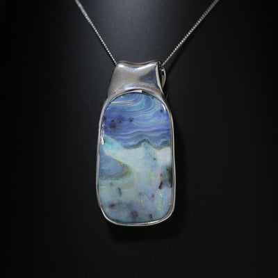 Australian Boulder opal is an opal that has the host ironstone rock forming naturally as part of the gem. There are often inclusions in the opal layer and because the layer follows the contours of natural ironstone the shape is often much undulated. The irregular shape of boulder opal makes it a designer’s delight and most pieces of jewelry using boulder opal are very unusual.
